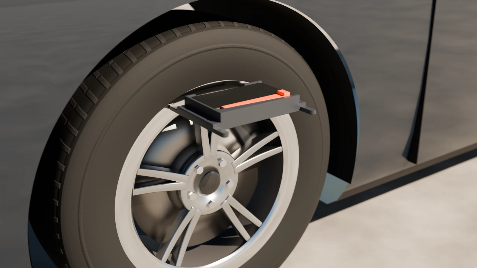 The bracket with a phone in it, flat on top of a car's front wheel with its prongs on the rim's lip